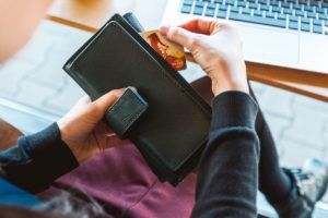 Woman pulling a small piece of paper out of her wallet.