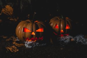 Spooky looking jackolanterns lit up with candles.