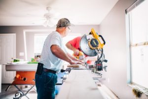 Two men using a power saw