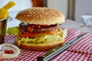 A burger on a gingham cloth. 