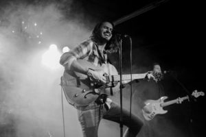 A man playing guitar at a concert