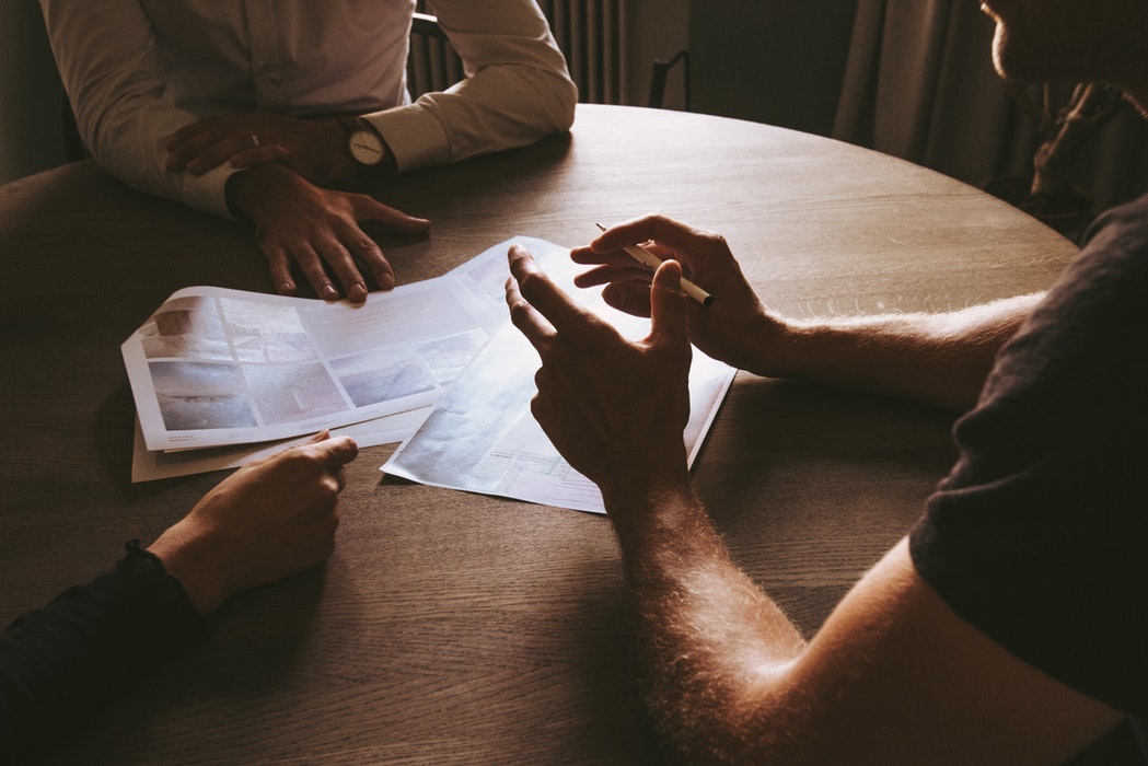 A group of people talking around a table.