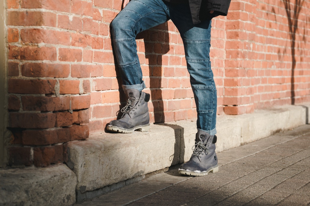 A person walking by a brick wall.