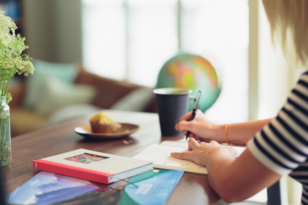 A woman writing in a planner.