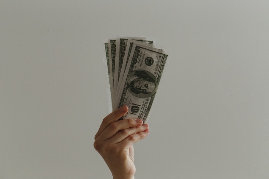 A person holding up money. 