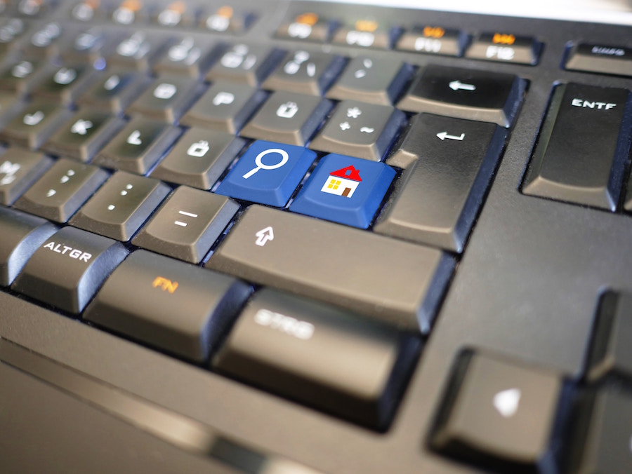 Computer with keys relating to real estate and an open house.