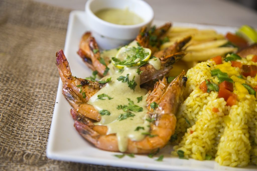 Prawns covered in sauce with a side of rice. 