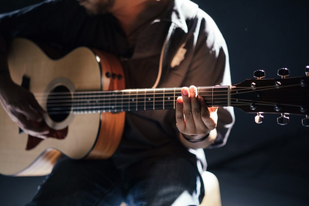 A man playing an acoustic guitar.