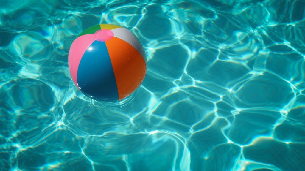 A beach ball floating in an indoor pool.