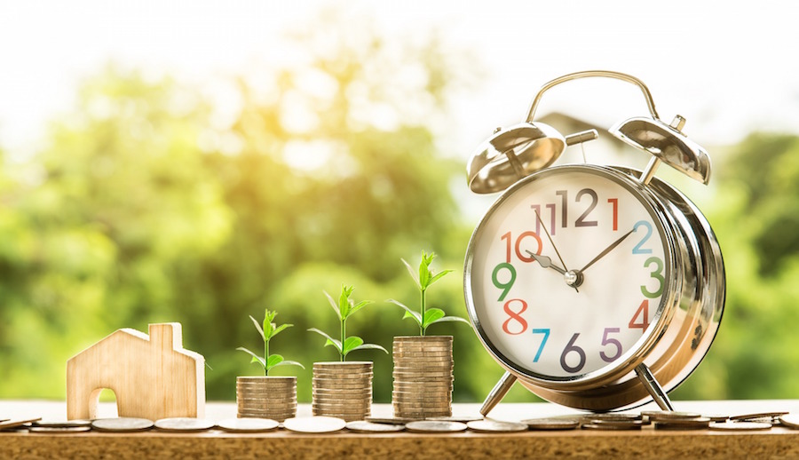 House figurine, coin stacks, and clock